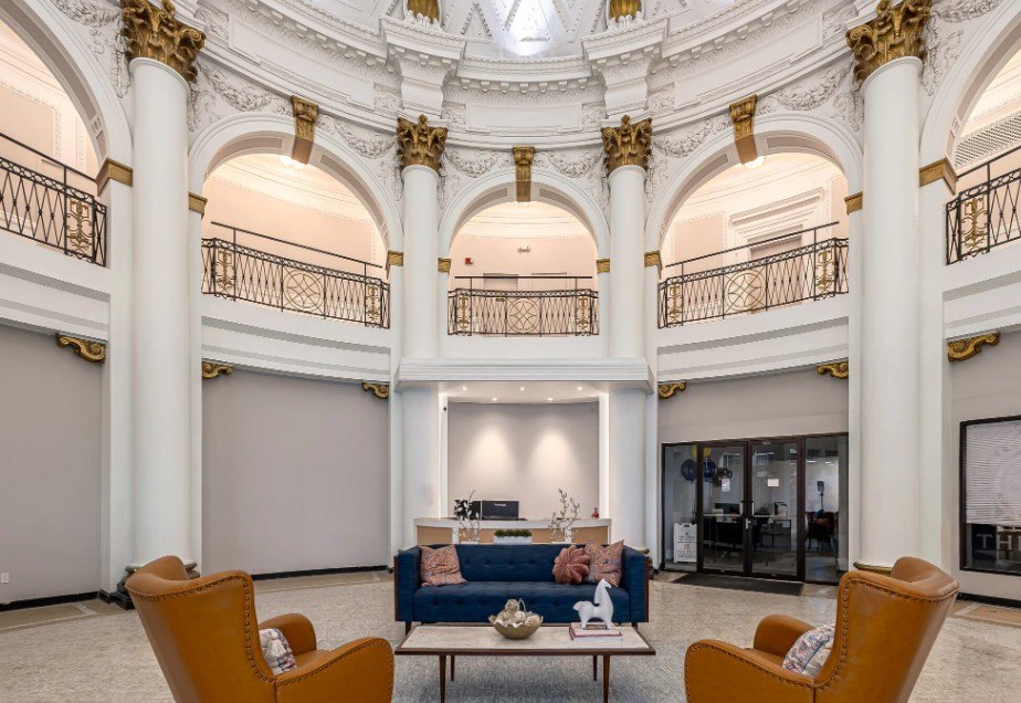 A large, ornate room with a balcony and a blue couch.